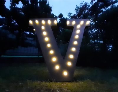 Lettera iniziale “V” luminosa in stile industriale